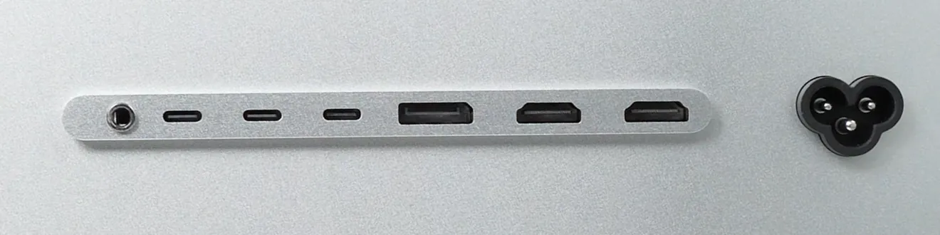 Близък план на редицата конектори на гърба на Kuycon G27P: аудио жак, три USB-C порта, един DisplayPort, два HDMI порта и захранващият вход